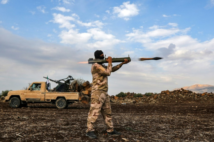 A Syrian fighter fires a rocket-propelleged grenade (RPG) during military drills by a Turkish-backed division in northern Syria