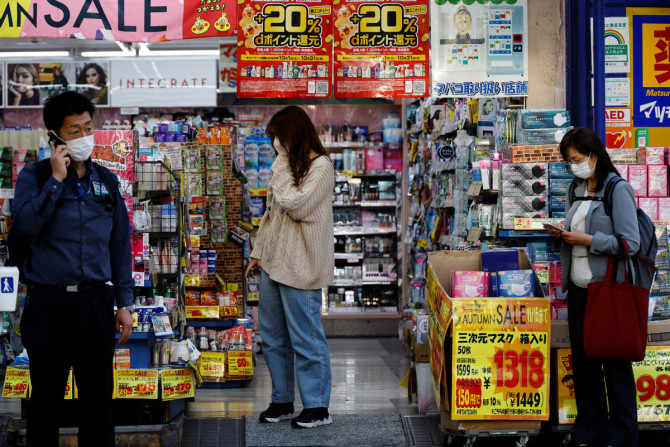 A woman chooses products at a drug store in Tokyo