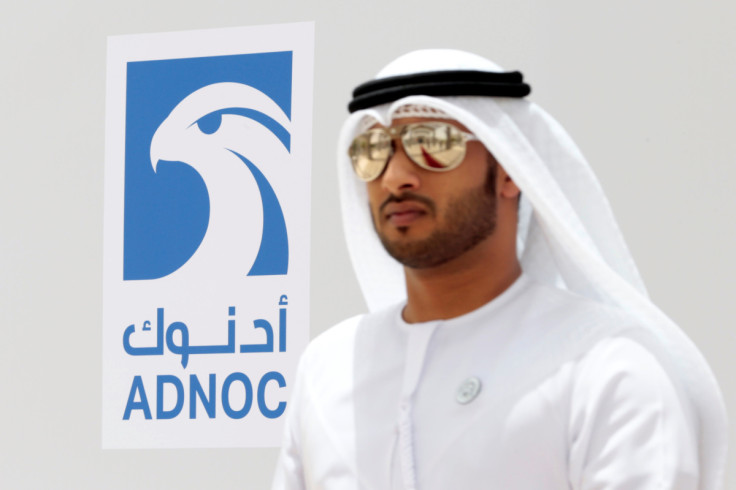 An Emirati man is seen near the logo of  ADNOC in Ruwais