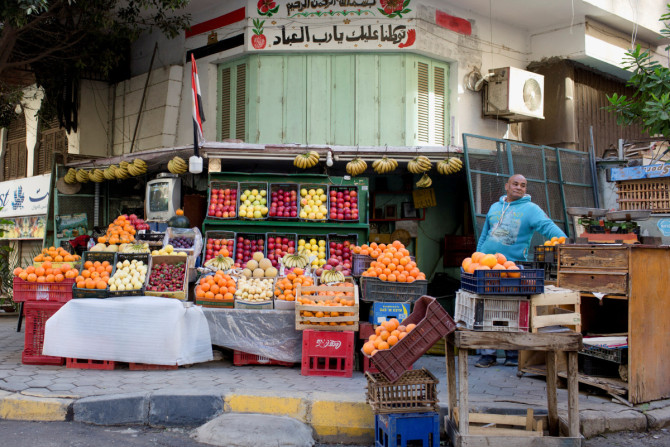 Egyptian vegetable and fruit seller waits for customers at a popular market in Cairo