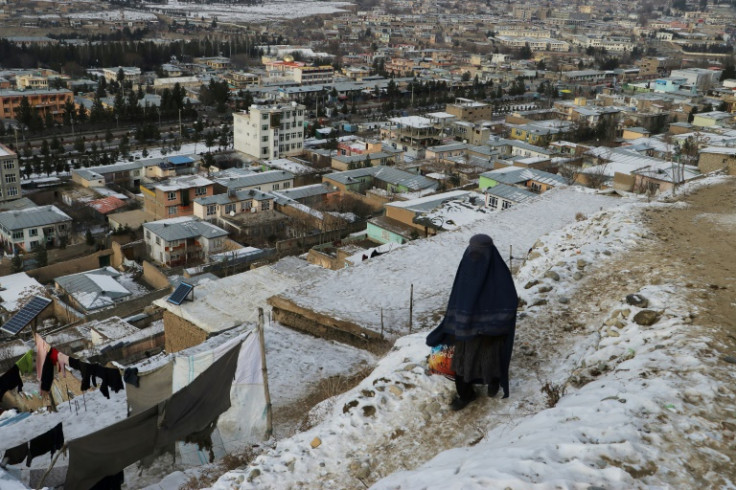 A woman walks down at a path during a cold winter day in Fayzabad of Badakhshan province in Afghanistan on January 18, 2023