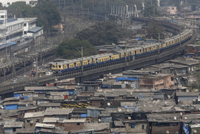 A suburban train passes through a slum area in Mumbai, India