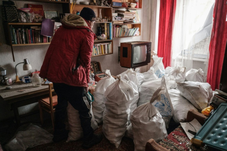 Bakhmut resident Oleksiy brings firewood to his neighbour's apartment