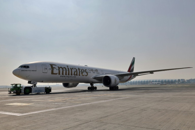 Ground crews prepare an Emirates Boeing 777-300ER aircraft, powering one of its engines with a hundred per cent Sustainable Aviation Fuel (SAF), for a demonstration flight at the Dubai International Airport in Dubai, on January 30, 2023. Emirates said it 