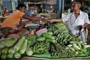 Nikhil Kumar Mondal buys vegetables from a vendor at a market on the outskirts of Kolkata