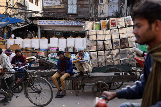 Workers sit on a cart at a wholesale market in the old quarters of Delhi