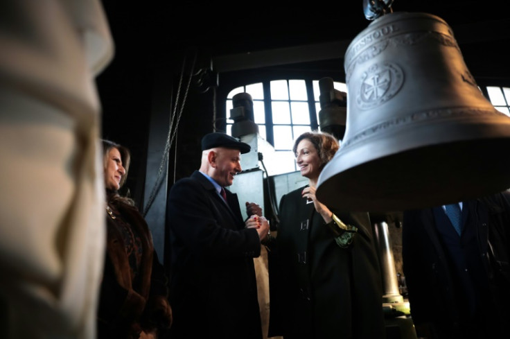 UNESCO Director-General Audrey Azoulay (C) shakes hands with Iraqi ambassador to France Wadee al-Batti on December 5, 2022 at the enveiling of a bell for Mosul's Our Lady of the Hour convent