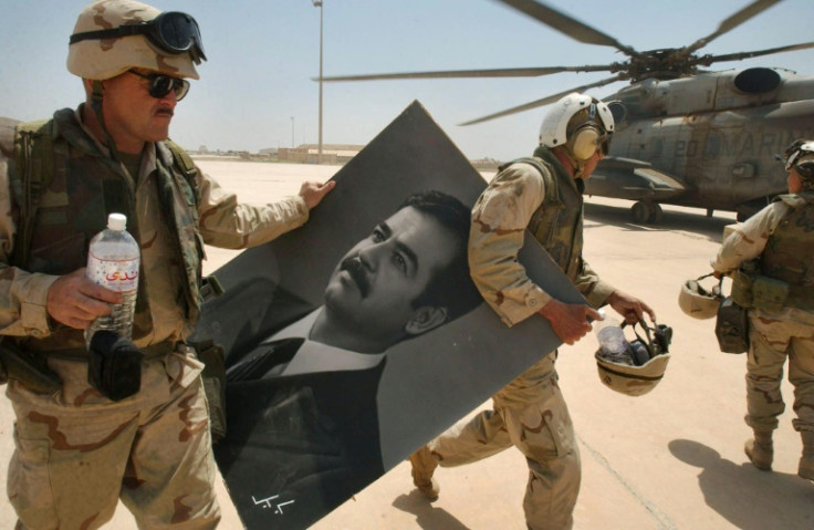 US Marines carry a portrait of toppled Iraqi president Saddam Hussein at the international airport in Baghdad, in this file photo from April 14, 2003