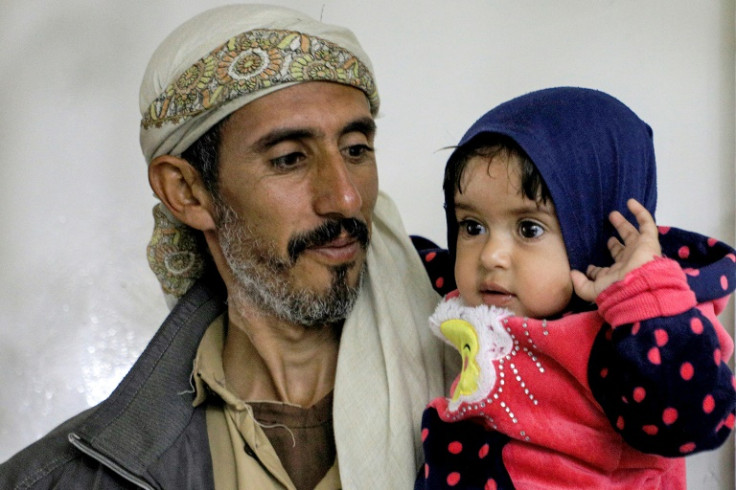 A man carries a child at al-Janatain Charity Medical Centre in Yemen's Huthi-rebel-held capital Sanaa