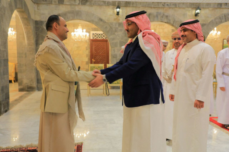 The head of the Houthi Supreme Political Council, Mahdi al-Mashat, shakes hands with Saudi ambassador to Yemen Mohammed Al-Jaber at the Republican Palace in Sanaa