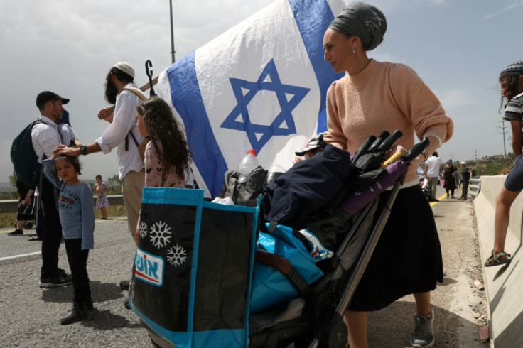 Israelis of all ages, including numerous armed men, walked to an outpost settlement built without approval from the state