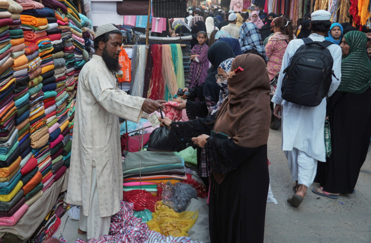 Muslim man sells garments to customers at a bazaar in Moradabad