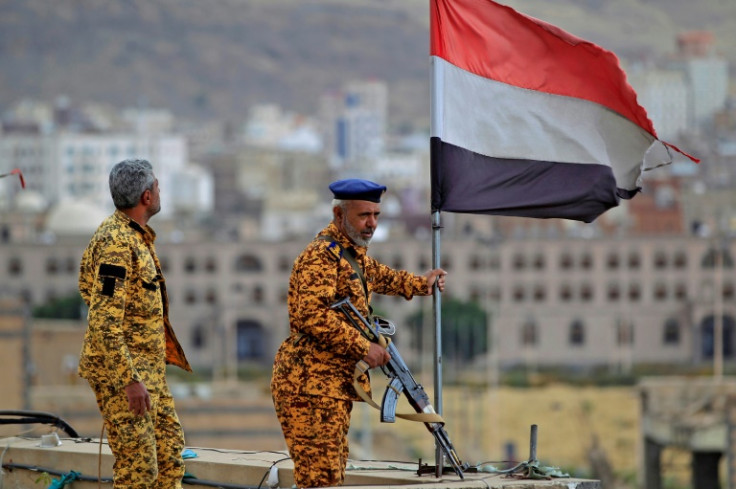 Fighters loyal to Yemen's Huthi rebels stand guard in the capital Sanaa during a rally on March 26, 2023