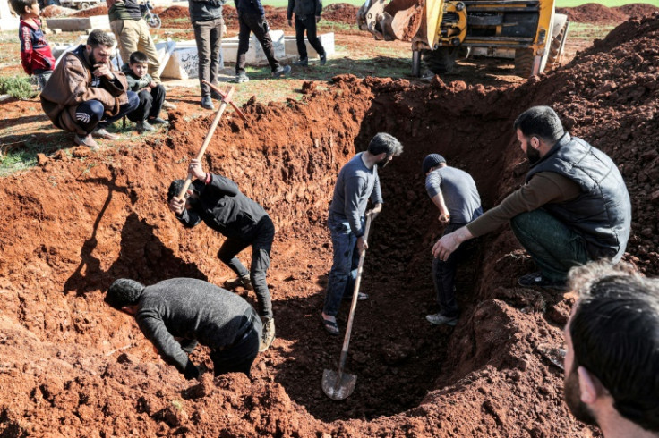 Diggers prepare a grave for victims of a reported bombardment by Syrian government forces, ahead of their mass funeral in the village of Maaret al-Naasan in Syria's rebel-held Idlib province on February 12, 2022