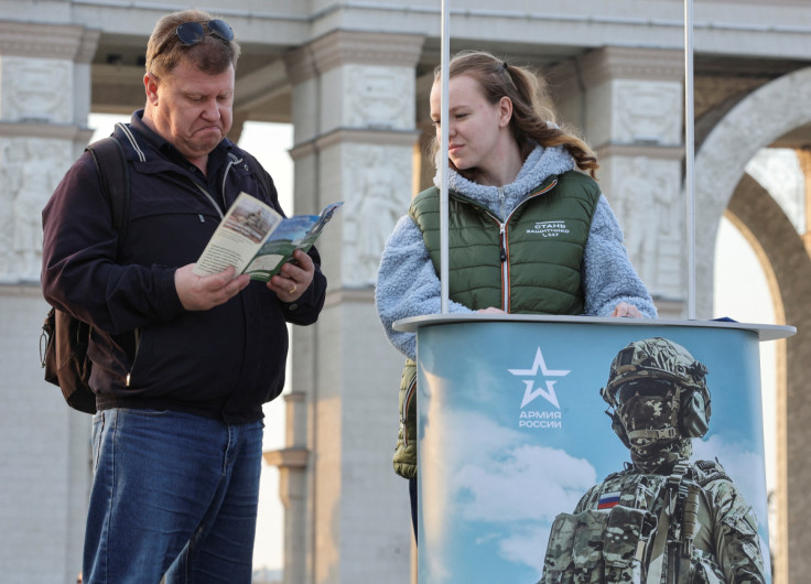 A man studies a leaflet promoting Russian army service in Moscow