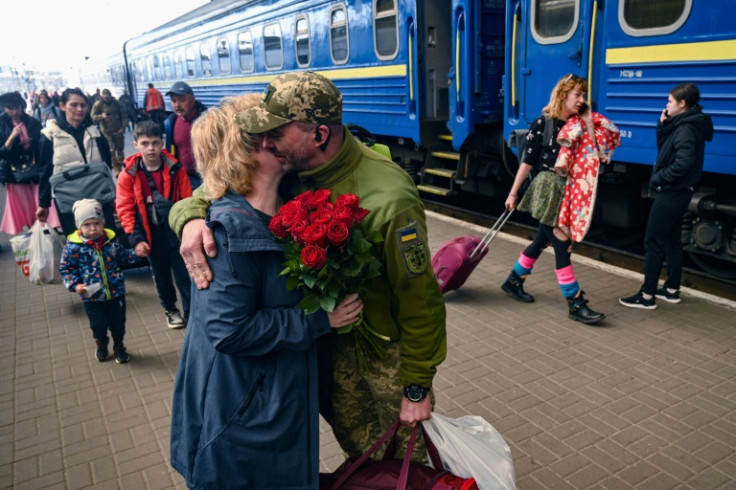 A woman embraces her husband, a Ukrainian serviceman, as he arrives by train in the western Ukrainian city of Lviv