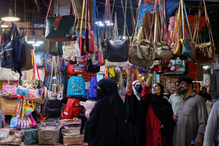 People look at handbags on display outside shops in a market, ahead of Eid al-Fitr celebrations in Karachi