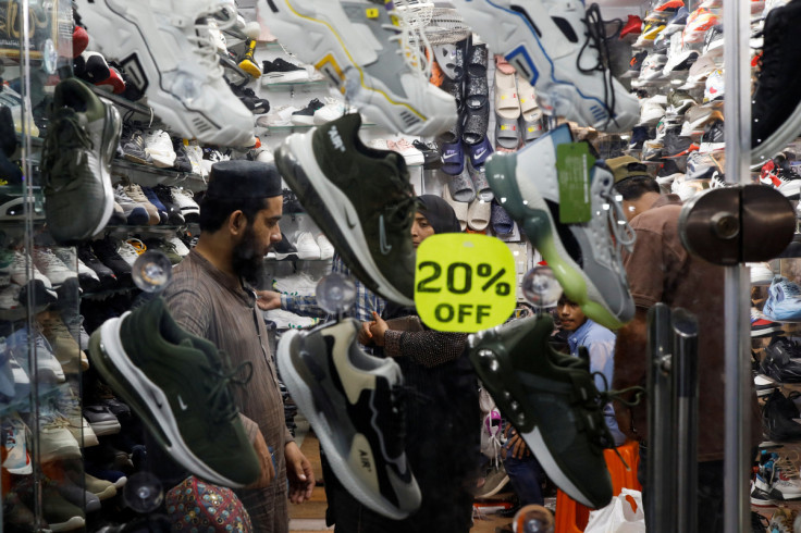 People shop for footwear at a market, ahead of Eid al-Fitr celebrations in Karachi