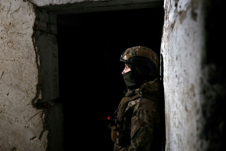A Ukrainian soldier stands in a shelter at front line positions near Bakhmut