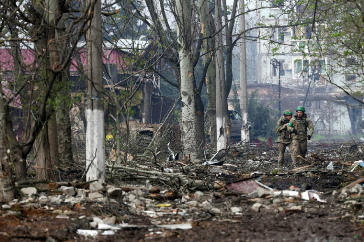 Ukrainian servicemen walk through debris in the frontline city of Bakhmut