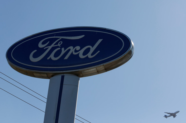 An airplane flies above a Ford logo in Colma, California