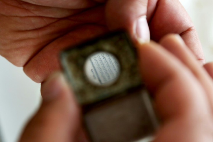 The Arabic text can only be read with a small magnifying glass embedded in the Koran's case