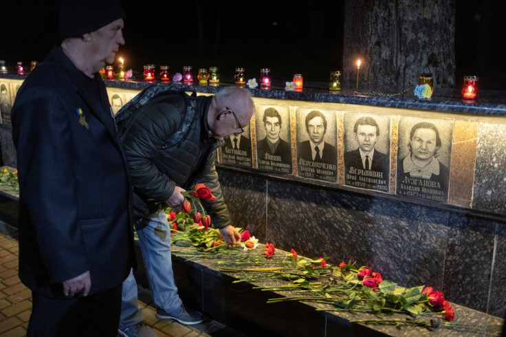 Former Chornobyl nuclear plant staff member Oleksandr Zabirchenko and Serhii Akulinin visit a memorial dedicated to their colleagues who died after the Chornobyl nuclear disaster, during a night commemorative service in Slavutych