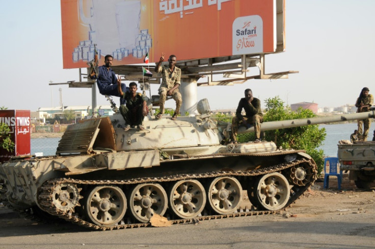 Sudanese army soldiers, loyal to army chief Abdel Fattah al-Burhan, sit atop a tank in Port Sudan