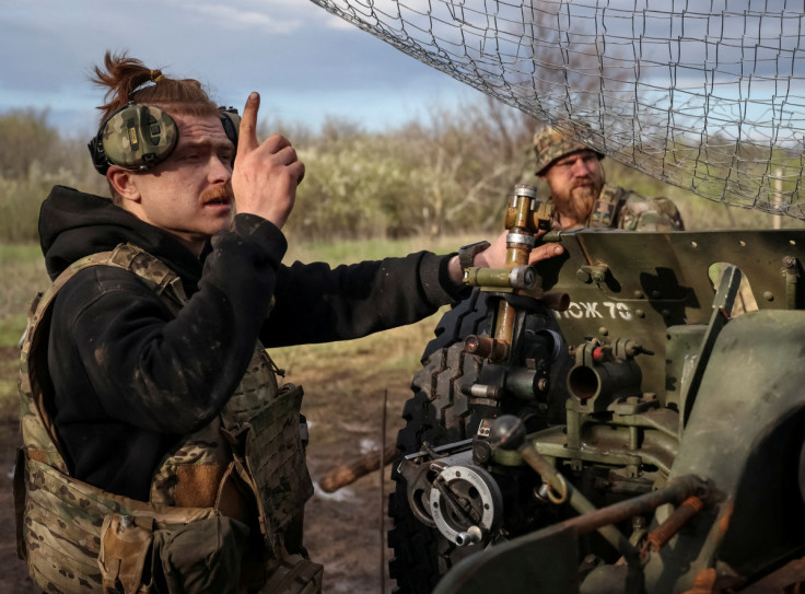 Ukrainian service members prepare fire a howitzer D30 at a front line near the city of Bakhmut