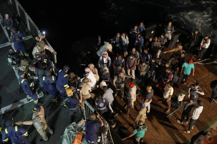 Saudi Royal Navy officials help civilians onboard their ship to be evacuated from Sudan, in Port Sudan