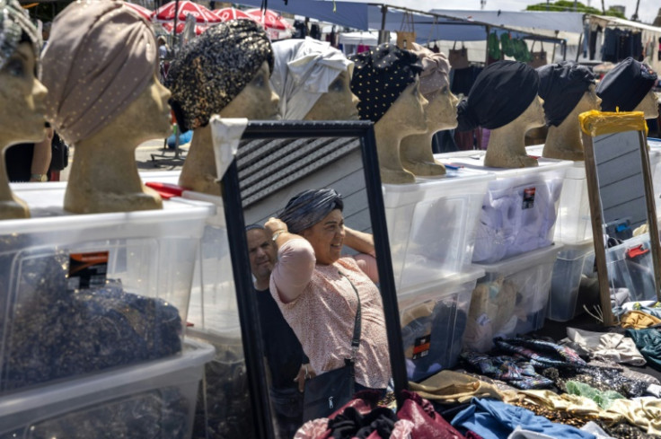 A woman shops at a low price market on a street in the southern Israeli city of Ashkelon