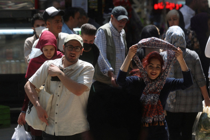 People walk on a street amid the implementation of the new hijab surveillance in Tehran