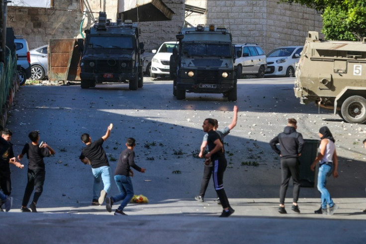 Palestinian residents hurl stones at Israeli troops carrying out their latest deadly raid on the flashpoint West Bank city of Nablus