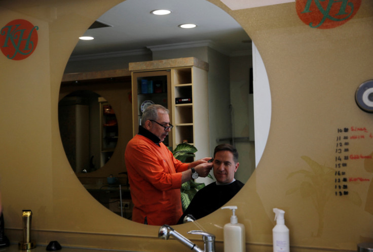 Barber Hakim Ekinci cuts his customer's hair at his shop in Istanbul