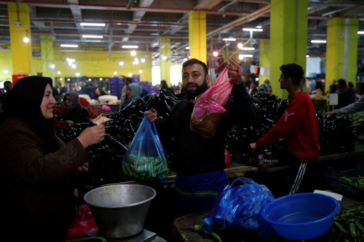 Vegetable vendor Cihan Bildik serves customers at a fresh market in Istanbul