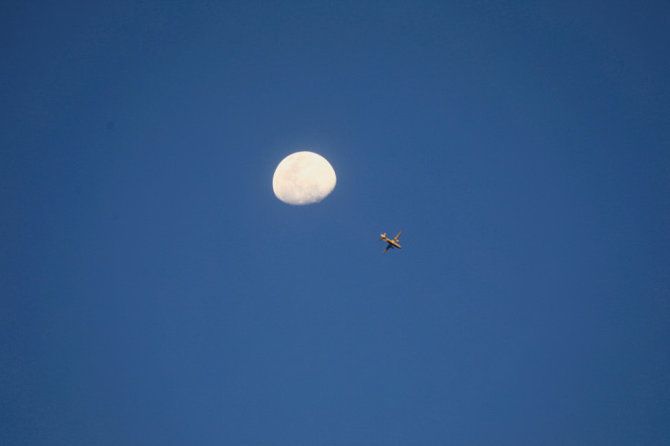 View of the moon while a strike aircraft prepares for an aerial bombardment in Khartoum