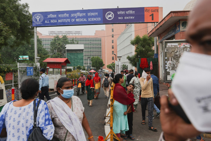 People walk across the road outside All India Institute of Medical Sciences (AIIMS) in New Delhi
