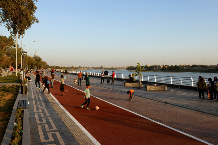 People walk at a promenade by the Tigris river and Abu Nawas park in Baghdad