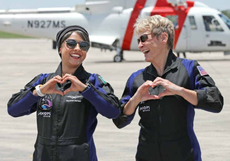 Axiom Mission 2 specialist Rayyanah Barnawi (L) of Saudi Arabia and commander and former NASA astronaut Peggy Whitson, of the United States, make heart shapes with their hands towards relatives ahead of their launch to the International Space Station