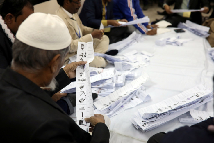 A presiding officer counts votes at a voting center after the session has ended in Dhaka