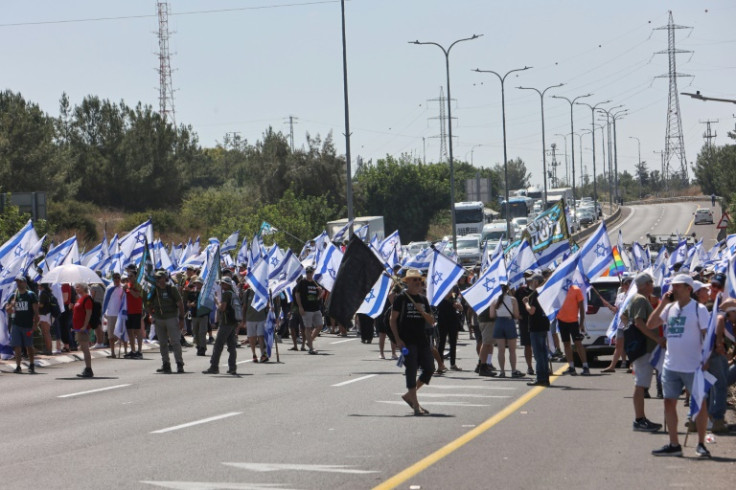 Demonstrators block Highway 443 between Jerusalem and Tel Aviv near the city of Modiin