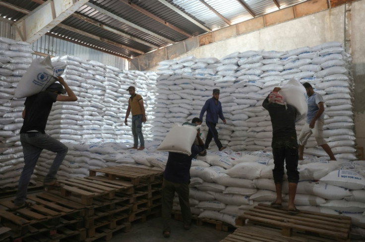 Workers unload bags of aid at a warehouse near the Syrian Bab al-Hawa border crossing with Turkey, on July 10, 2023