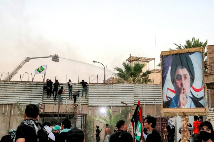 Supporters of Iraqi Shiite cleric Moqtada Sadr climb the fence outside the Swedish embassy in Baghdad