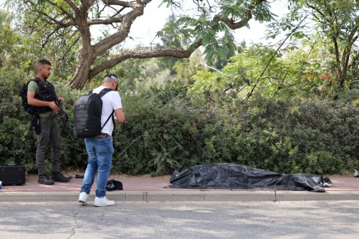 Israeli security men near the covered body of the gunman