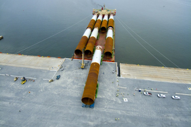 Steel monopile foundations for the Coastal Virginia Offshore Wind commercial project are offloaded at Portsmouth Marine Terminal in Portsmouth, Virginia