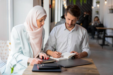 Women in hijab at workplace working with men