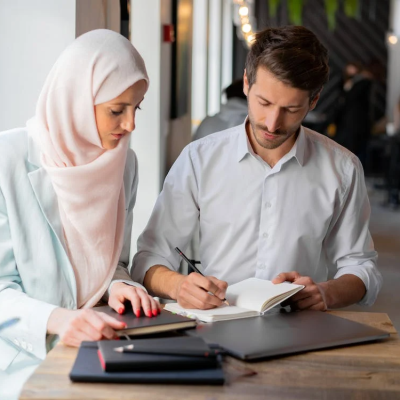 Women in hijab at workplace working with men