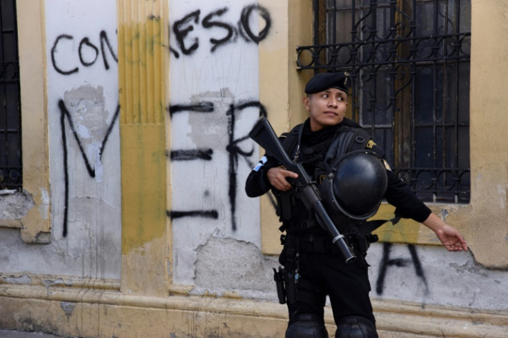 A policeman stands outside the Guatemalan Congress where scuffles broke out a night earlier