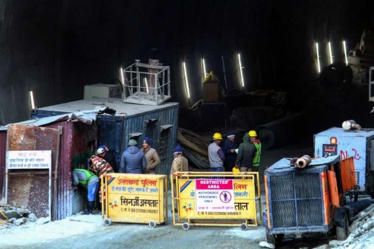 Police and officials stand at the entrance of the road tunnel that collapsed in India's Uttarakhand state
