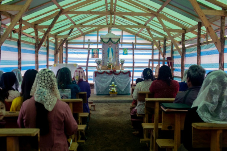Families pray in a makeshift church at a camp for internally displaced people in Myanmar's Kayah state